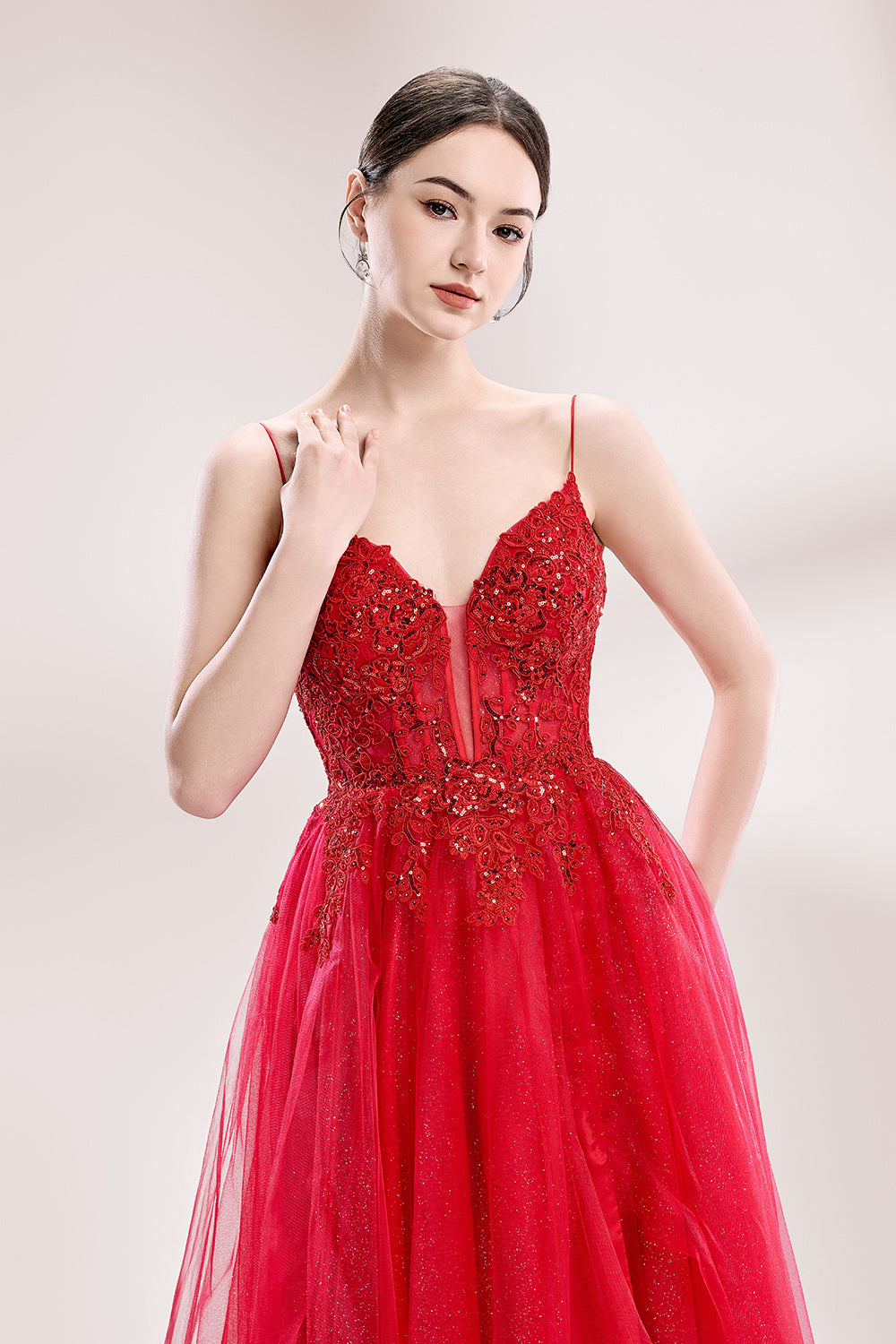 A woman stands against a light background, wearing a red tulle gown. It features thin straps, a deep V - neckline, intricate lace embroidery with sequins on the bodice, and a high side slit. The voluminous tulle skirt creates a romantic and glamorous look, perfect for formal events like proms or weddings.3