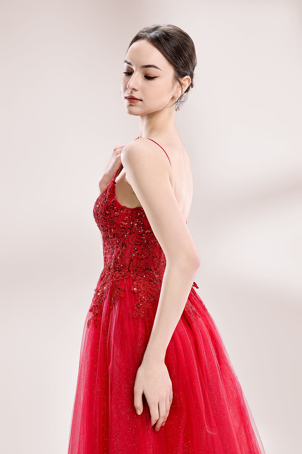 A woman stands against a light background, wearing a red tulle gown. It features thin straps, a deep V - neckline, intricate lace embroidery with sequins on the bodice, and a high side slit. The voluminous tulle skirt creates a romantic and glamorous look, perfect for formal events like proms or weddings.4