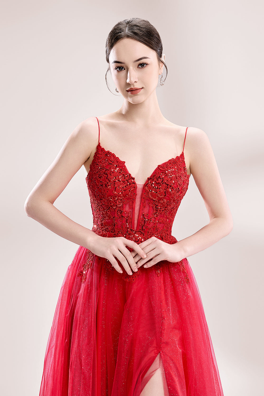 A woman stands against a light background, wearing a red tulle gown. It features thin straps, a deep V - neckline, intricate lace embroidery with sequins on the bodice, and a high side slit. The voluminous tulle skirt creates a romantic and glamorous look, perfect for formal events like proms or weddings.5