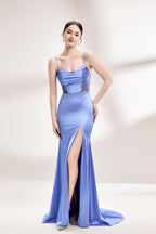 A woman with sleek dark hair and a poised stance wears a light - blue satin gown. It has thin straps, a cowl neckline, sheer mesh side panels, and a high side slit. Paired with understated earrings, the outfit radiates elegance, perfect for formal events like galas or evening receptions.1