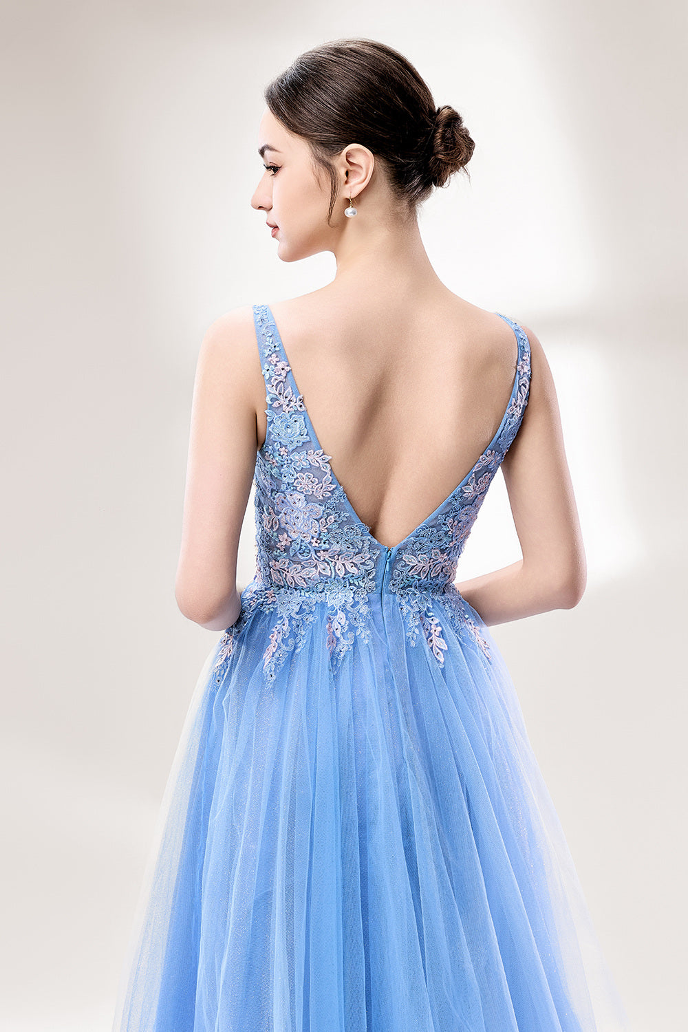Bathed in soft light, a woman stands out in a light blue tulle gown. It has a deep V - neckline with delicate lace embroidery on the bodice, and a flowing tulle skirt. The ethereal design creates a romantic and dreamy look, perfect for formal events like proms or weddings.6