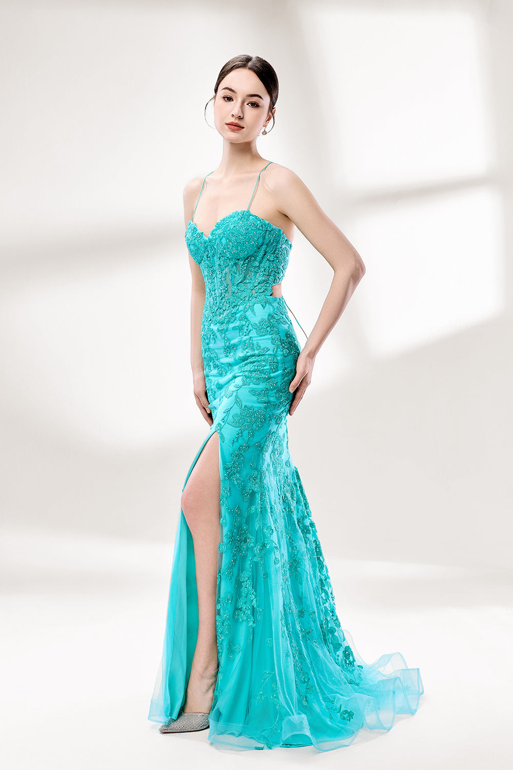 Set against a light background, a woman dons a turquoise tulle gown adorned with floral lace. It has thin straps, a sweetheart neckline, and a mermaid - shaped skirt with a high side slit. The delicate lace and flowing fabric exude romance, ideal for weddings or formal dinners.3