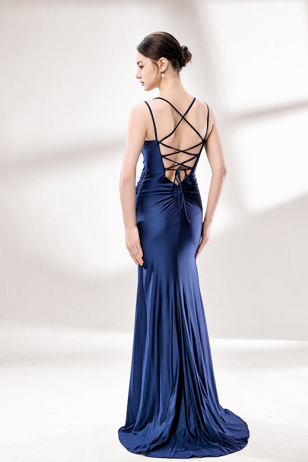 Set against a light background, a woman wears a navy - blue satin gown. It boasts thin straps, a draped neckline, and a mermaid silhouette with a high side slit. The smooth fabric and ruched design exude sophistication, ideal for formal events like proms.2