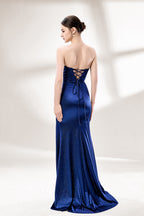 This is a strapless royal - blue gown. It features a twisted - front design at the bustline, with a sheer panel in the middle of the bodice. The waist is cinched with ruched detailing, and the skirt is mermaid - shaped with a high side slit. Paired with silver - glittered heels, it exudes elegance and sensuality, perfect for formal events like galas or balls.2
