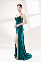 Photograph of a young Caucasian woman with fair skin and dark brown hair styled in an elegant updo. She is wearing a stunning, floor-length, teal evening gown with a deep V-neckline adorned with intricate beadwork. The gown features a high slit on the left, showcasing her slender legs. The fabric has a smooth, shimmering texture. The background is a soft, white gradient, creating a minimalist and elegant atmosphere. The overall style is sophisticated and glamorous, suitable for formal events.6
