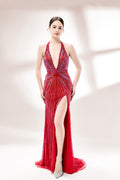 Set against a light backdrop, a woman wears a red halter - neck gown. It features a deep V - neckline, intricate sparkling beadwork, and a high side slit. The glamorous design creates an eye - catching and elegant look, perfect for formal events like galas or red - carpet moments.1