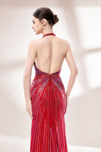 Set against a light backdrop, a woman wears a red halter - neck gown. It features a deep V - neckline, intricate sparkling beadwork, and a high side slit. The glamorous design creates an eye - catching and elegant look, perfect for formal events like galas or red - carpet moments.5