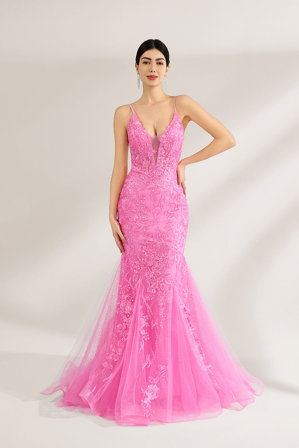 A woman stands against a light background, wearing a pink tulle - and - lace mermaid gown. It has thin straps, a deep V - neckline, and intricate floral lace patterns. The flowing tulle skirt adds romance, combining elegance and charm, perfect for formal events like weddings or galas.1