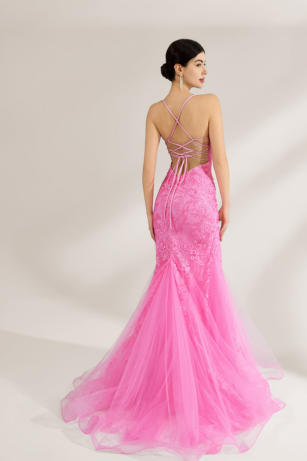 A woman stands against a light background, wearing a pink tulle - and - lace mermaid gown. It has thin straps, a deep V - neckline, and intricate floral lace patterns. The flowing tulle skirt adds romance, combining elegance and charm, perfect for formal events like weddings or galas.2