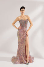 A woman with sleek dark hair and a confident stance wears a multi - colored, sequined strapless gown. It has a form - fitting silhouette, a high side slit, and bead - detailed bodice. Paired with silver heels, the outfit radiates glamour, perfect for formal events like galas or award ceremonies.1