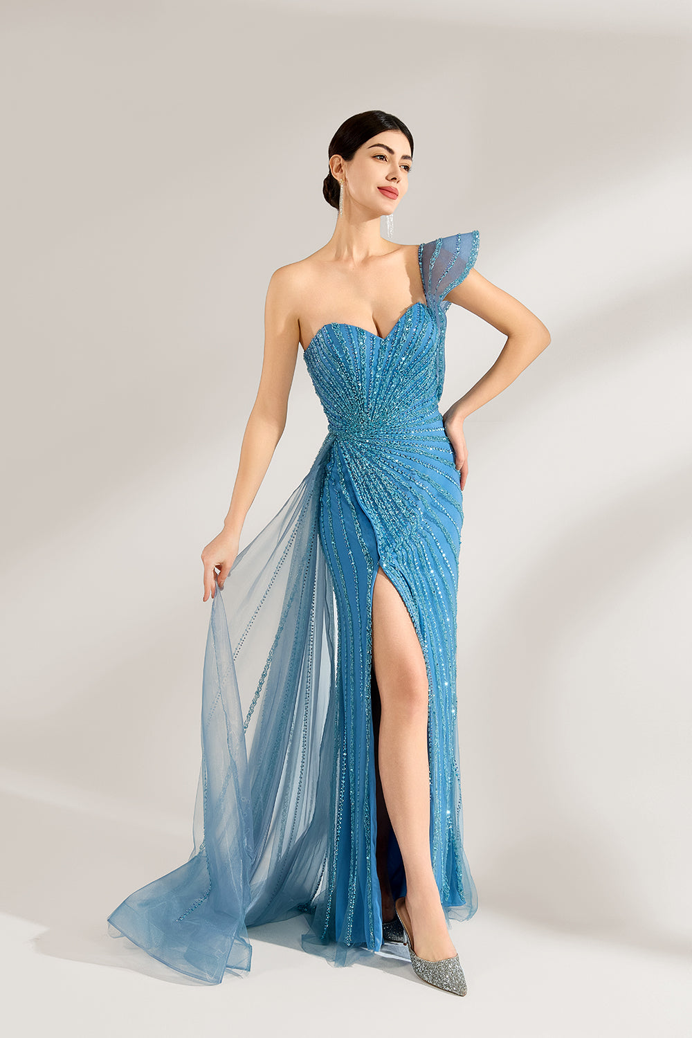 Bathed in soft light, a woman radiates elegance in a blue evening gown. With one - shoulder design, sequin detailing, and a high slit, it crafts a glamorous and sophisticated look for formal events.5