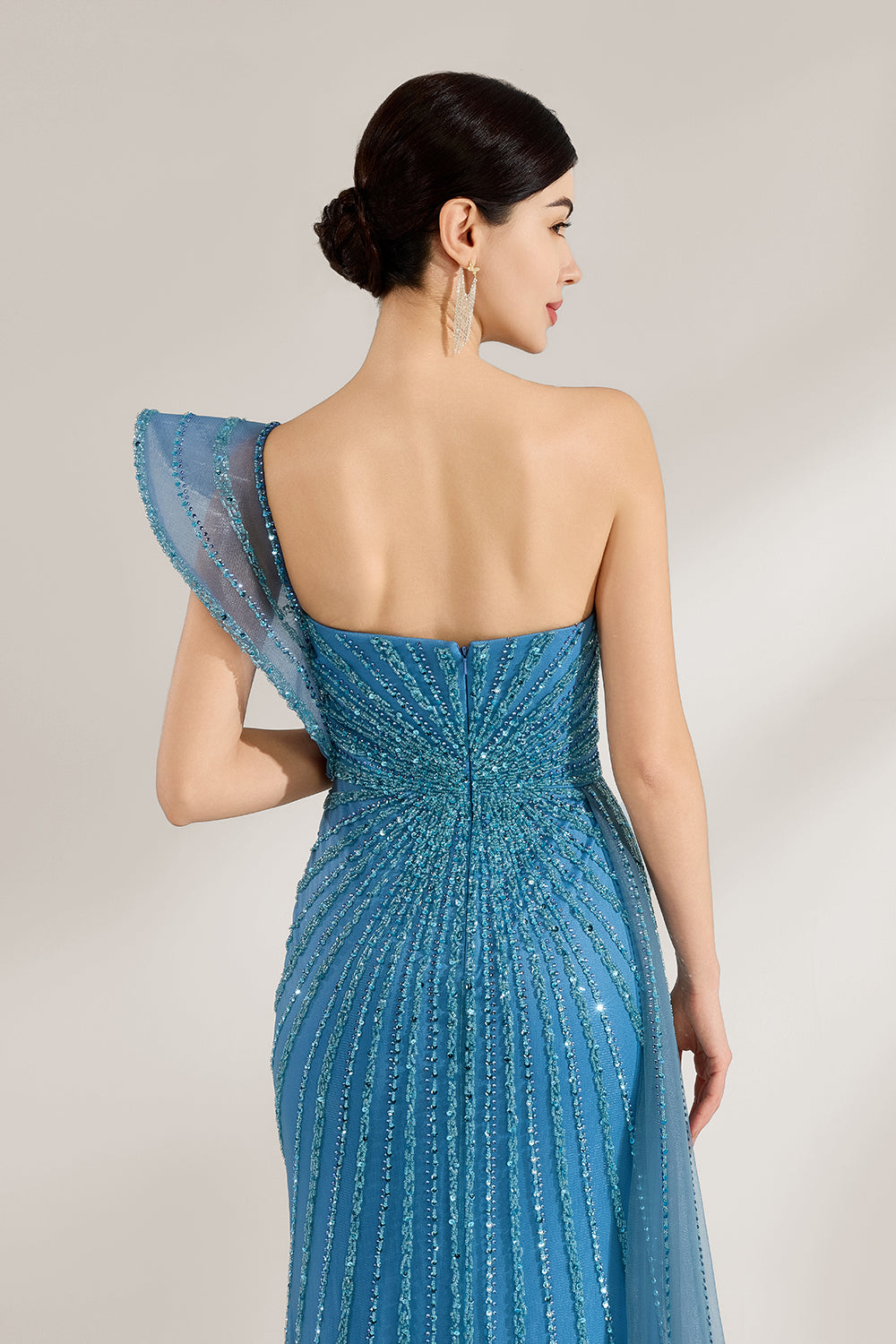 Bathed in soft light, a woman radiates elegance in a blue evening gown. With one - shoulder design, sequin detailing, and a high slit, it crafts a glamorous and sophisticated look for formal events.6