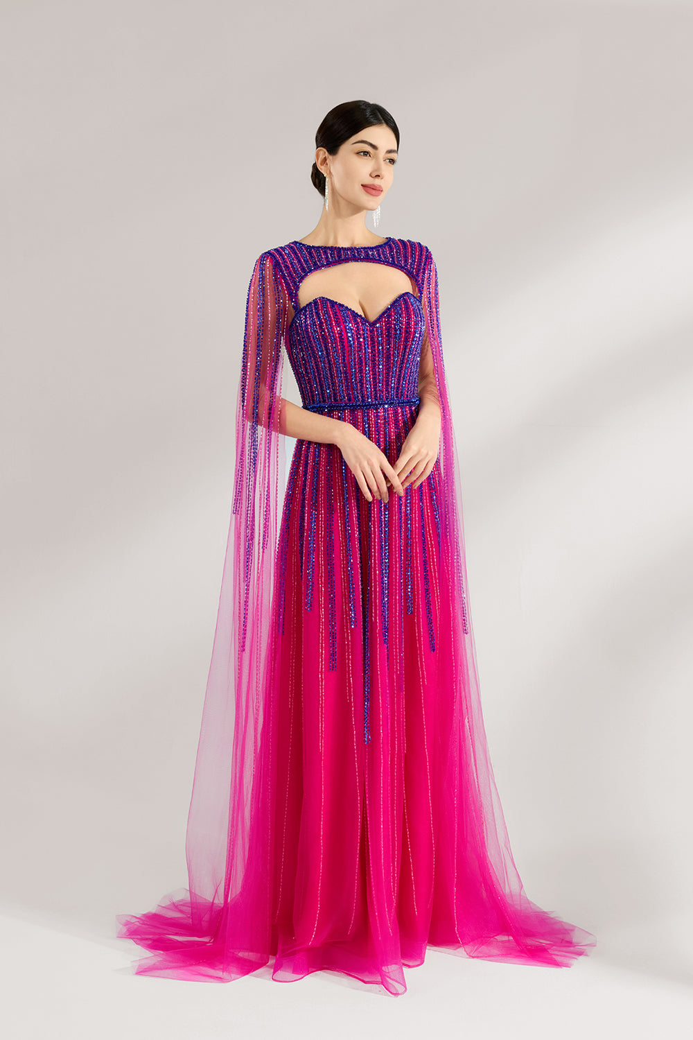 Illuminated softly, a woman enchants in a pink - purple gradient gown. With sequin detailing, a cut - out neckline, and a tulle cape, it creates a magical and elegant look for formal events.3