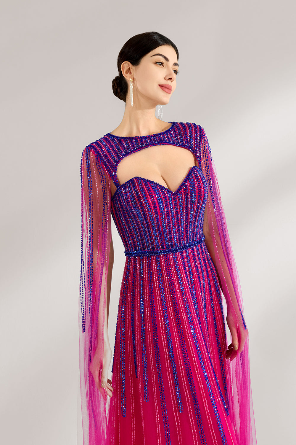 Illuminated softly, a woman enchants in a pink - purple gradient gown. With sequin detailing, a cut - out neckline, and a tulle cape, it creates a magical and elegant look for formal events.6