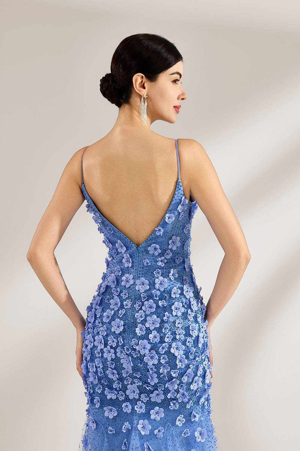A woman stands against a light background, wearing a light - blue tulle gown. It features thin straps, a deep V - neckline, intricate 3D floral appliqués with sequins on the bodice and skirt, and a mermaid silhouette with a trailing tulle skirt. The elegant design creates a romantic and glamorous look, perfect for formal events like proms or weddings.6