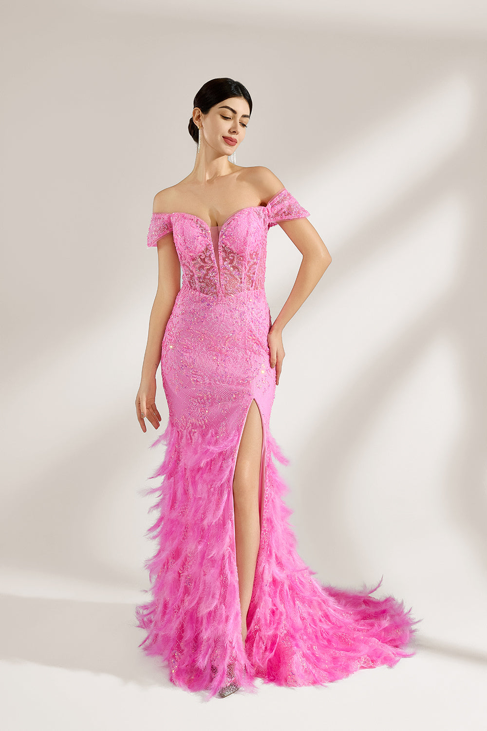 A woman stands against a light background, wearing a pink feather - trimmed gown. It features an off - shoulder neckline, sheer lace panels at the bodice, and a high side slit. The feathered skirt and intricate lace create a glamorous, romantic look, perfect for formal events like galas or weddings, exuding elegance and charm.1