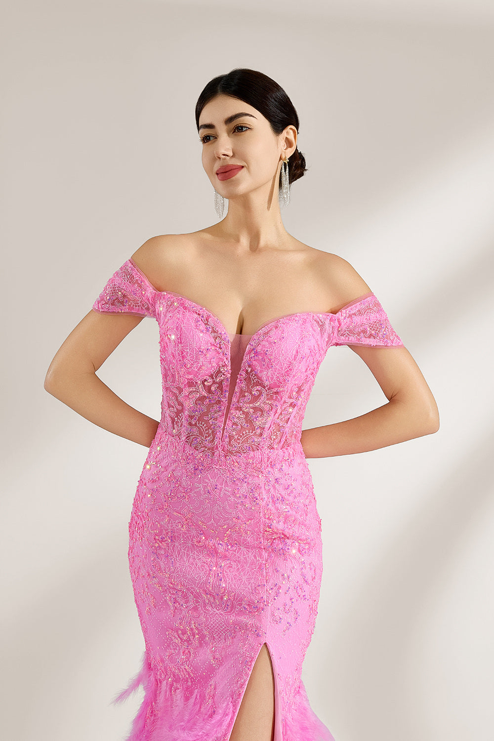 A woman stands against a light background, wearing a pink feather - trimmed gown. It features an off - shoulder neckline, sheer lace panels at the bodice, and a high side slit. The feathered skirt and intricate lace create a glamorous, romantic look, perfect for formal events like galas or weddings, exuding elegance and charm.3