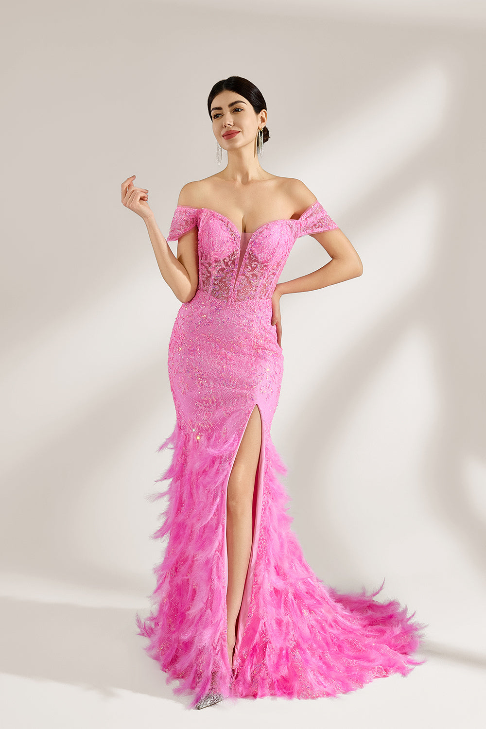 A woman stands against a light background, wearing a pink feather - trimmed gown. It features an off - shoulder neckline, sheer lace panels at the bodice, and a high side slit. The feathered skirt and intricate lace create a glamorous, romantic look, perfect for formal events like galas or weddings, exuding elegance and charm.4