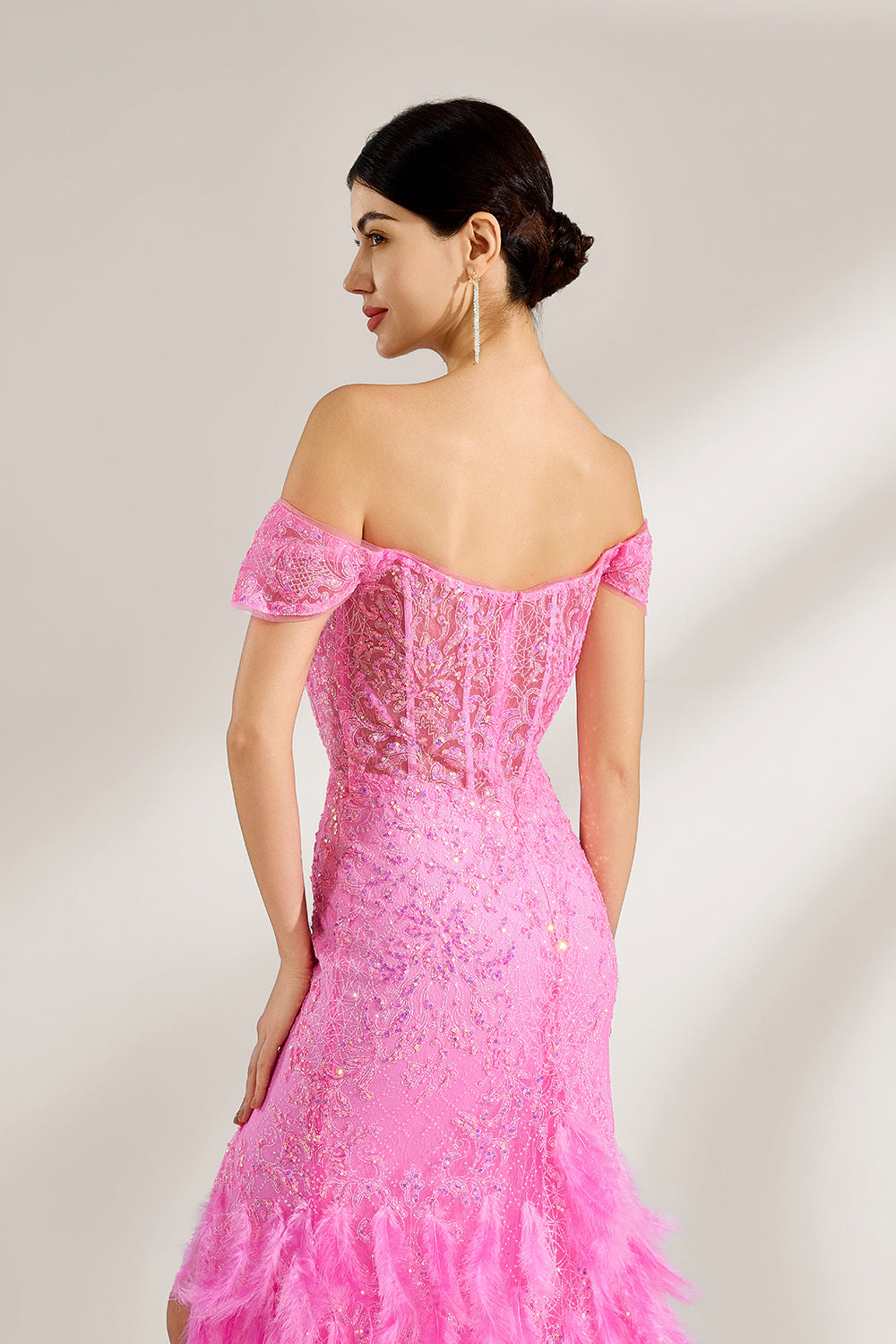 A woman stands against a light background, wearing a pink feather - trimmed gown. It features an off - shoulder neckline, sheer lace panels at the bodice, and a high side slit. The feathered skirt and intricate lace create a glamorous, romantic look, perfect for formal events like galas or weddings, exuding elegance and charm.5