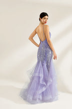 A woman stands against a light background, wearing a lavender mermaid gown. It has thin straps, a deep V - neckline, and is adorned with intricate silver bead patterns. The layered tulle skirt adds a romantic touch, perfect for formal events like galas or weddings, exuding elegance and charm.2