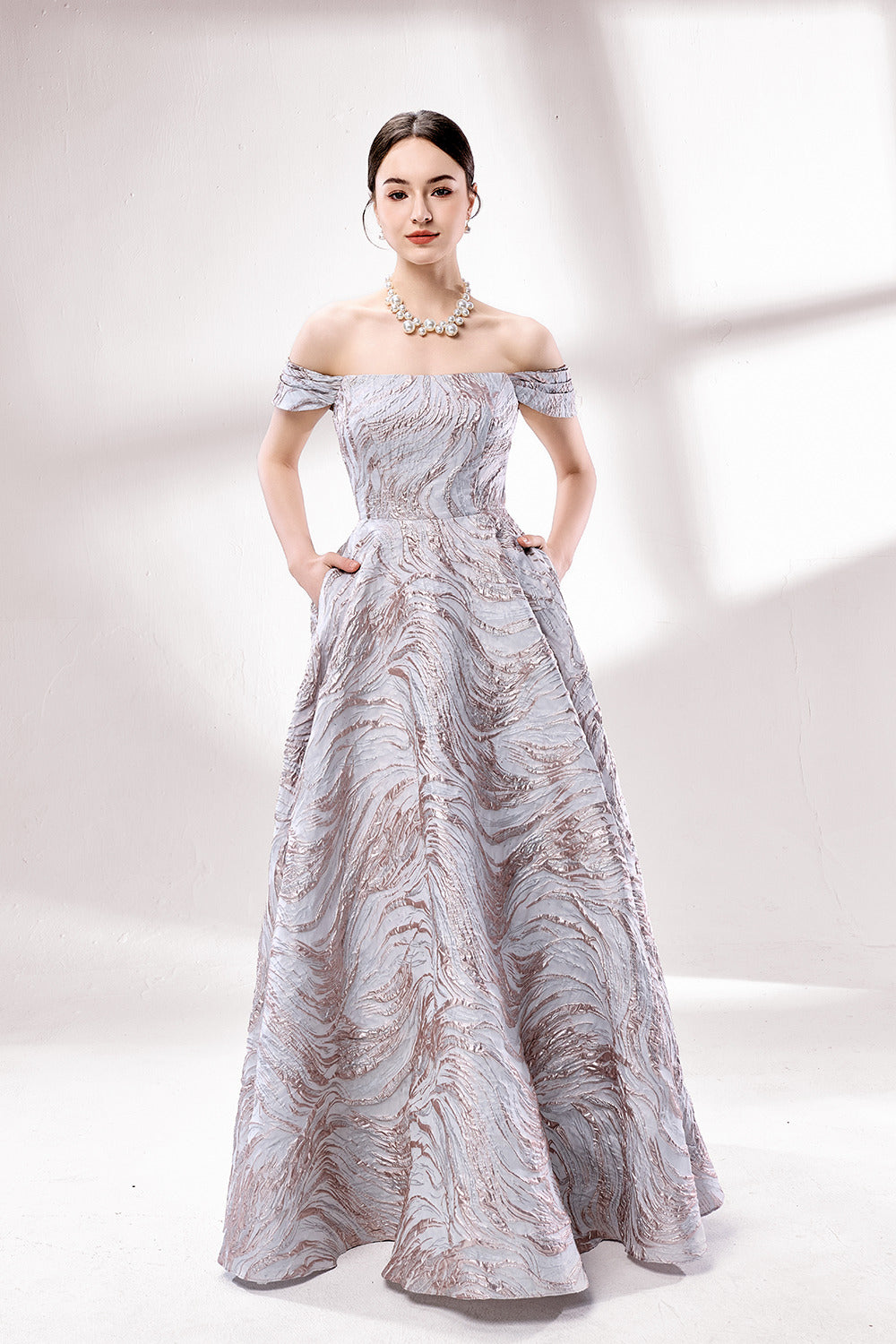 Set against a light backdrop, a woman dons an off - shoulder, light - purple gown with a marble - like pattern. It has short sleeves, a fitted bodice, and a full skirt, along with pockets for practicality. The unique pattern and elegant design make it ideal for formal gatherings, radiating sophistication.1