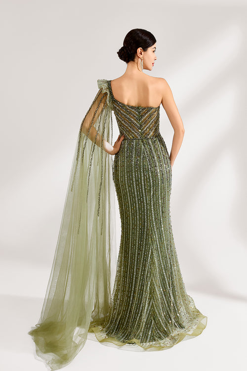 Illuminated softly, a woman captivates in an olive - green one - shoulder evening gown. The sequined mermaid silhouette, paired with a tulle cape, creates a striking and elegant look for formal events.2