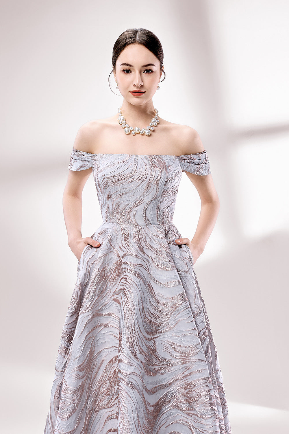 Set against a light backdrop, a woman dons an off - shoulder, light - purple gown with a marble - like pattern. It has short sleeves, a fitted bodice, and a full skirt, along with pockets for practicality. The unique pattern and elegant design make it ideal for formal gatherings, radiating sophistication.3