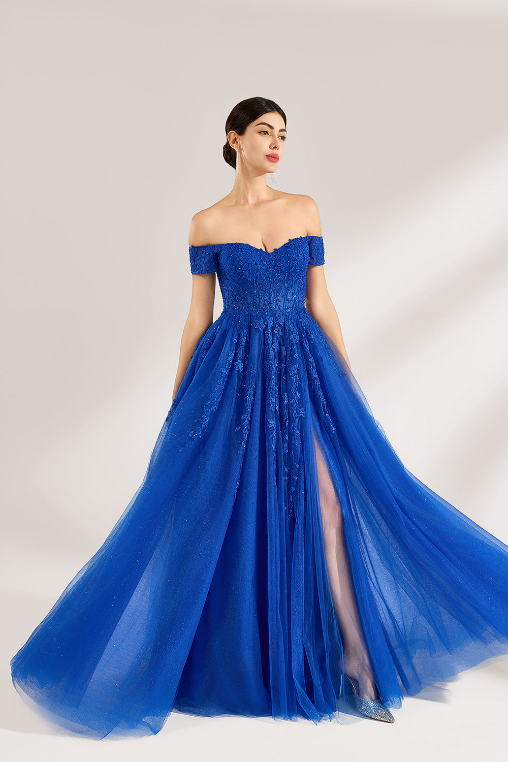 A woman poses against a light backdrop in a royal - blue tulle off - shoulder gown. The dress boasts a sweetheart neckline, delicate lace embroidery with a hint of shimmer on the bodice and skirt, plus a high side slit. Its elegant style gives off a romantic and glamorous vibe, ideal for formal events such as proms or weddings1