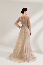 Bathed in soft light, a woman exudes elegance in a light beige sequined evening gown. With long sleeves, a criss - cross V - neck, and tulle - paneled skirt, it creates a glamorous and refined look for formal events.2