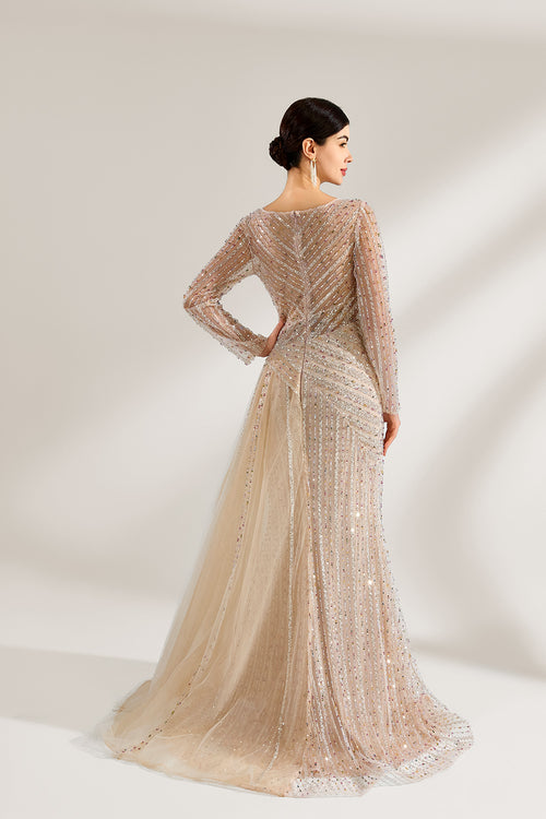 Front view of a luxury champagne gold A-line evening gown featuring a V-neck bodice fully adorned with shimmering hand-beaded embellishments, sheer long sleeves, and a long floor-length skirt with a draped tulle side train, perfect for a wedding, gala, or formal evening event and available for custom bulk orders or wholesale purchase.