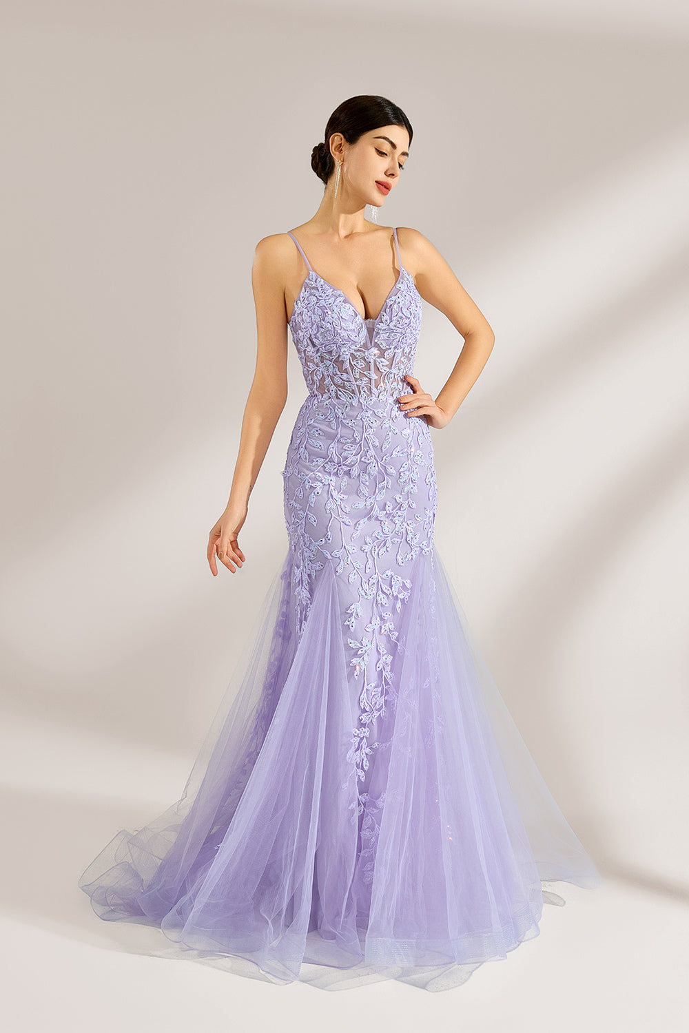 The model sports neatly arranged hair and dangles elegant long earrings. The gown is lavender, featuring a deep V - neckline and slender spaghetti straps. Intricate floral lace embellishes it, and the mermaid - cut skirt, crafted from airy tulle, exudes an elegant and dreamy charm, ideal for formal events.4