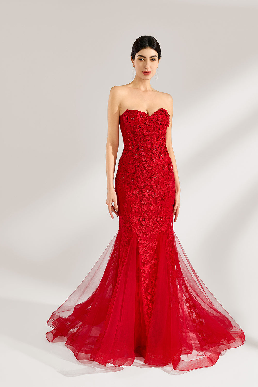 A woman stands against a light background, wearing a red mermaid - style gown. It features a strapless sweetheart neckline, intricate floral lace embroidery throughout, and a flowing tulle skirt with a train. The elegant design creates a glamorous and romantic look, perfect for formal events like proms or weddings.3