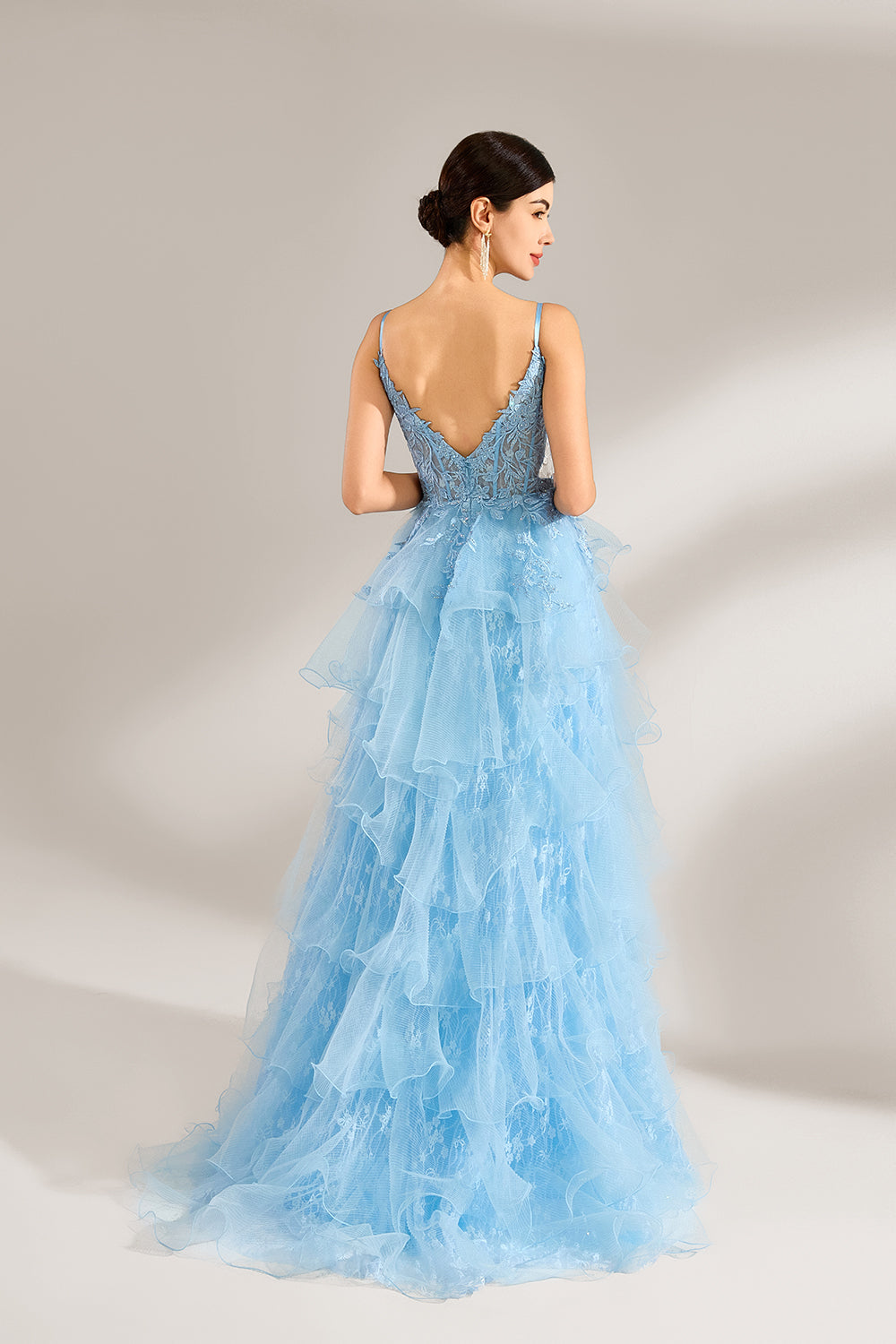 A woman stands against a light background, wearing a light - blue tulle gown. It has thin straps, a deep V - neckline, and intricate lace embroidery on the bodice. The layered, ruffled skirt with a high side slit creates a romantic and glamorous look, perfect for formal events like proms or weddings, exuding elegance and charm.2