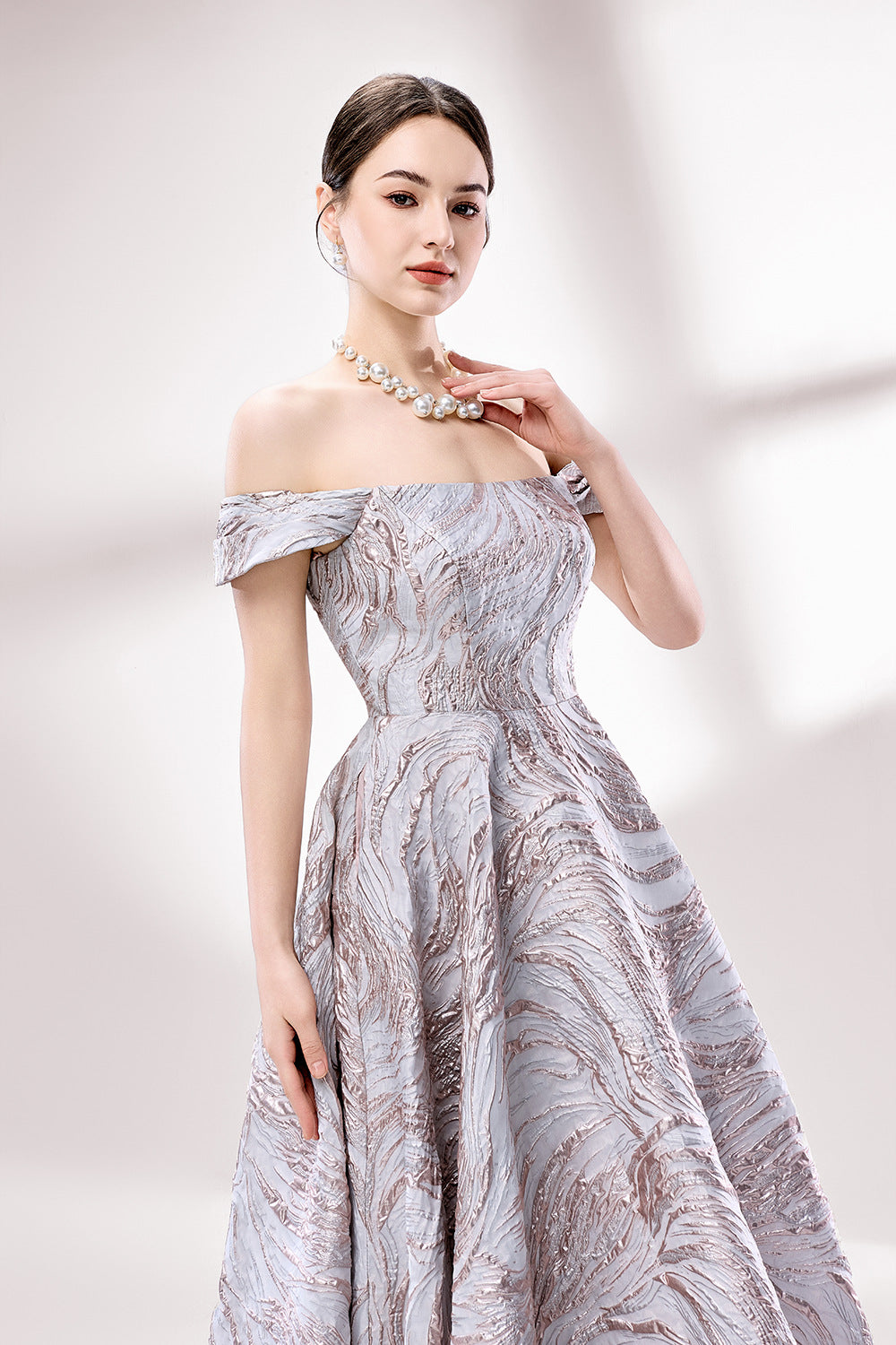 Set against a light backdrop, a woman dons an off - shoulder, light - purple gown with a marble - like pattern. It has short sleeves, a fitted bodice, and a full skirt, along with pockets for practicality. The unique pattern and elegant design make it ideal for formal gatherings, radiating sophistication.5