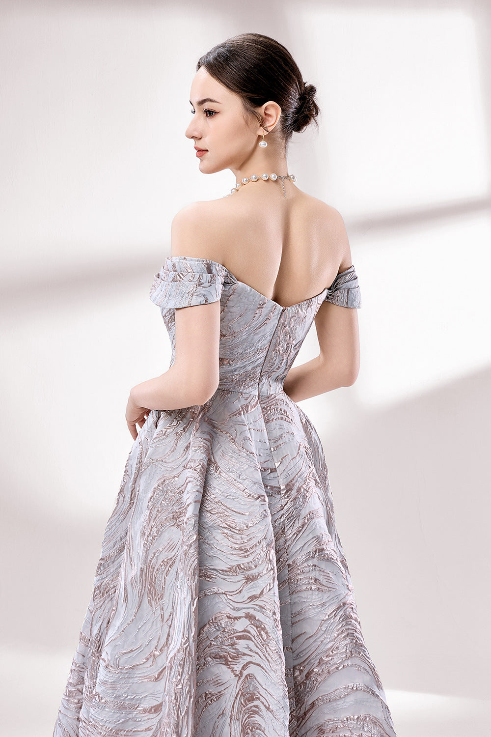 Set against a light backdrop, a woman dons an off - shoulder, light - purple gown with a marble - like pattern. It has short sleeves, a fitted bodice, and a full skirt, along with pockets for practicality. The unique pattern and elegant design make it ideal for formal gatherings, radiating sophistication.6