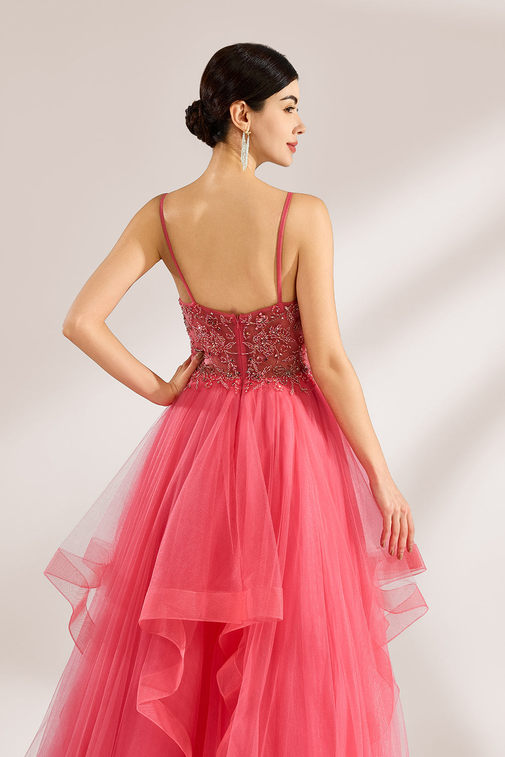 A woman stands against a light background, wearing a coral - pink tulle gown. It features thin straps, a deep V - neckline, and intricate bead embroidery on the bodice. The layered, ruffled tulle skirt creates a romantic and voluminous look, perfect for formal events like proms or weddings.6