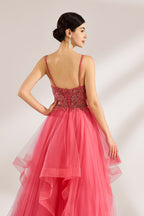 A woman stands against a light background, wearing a coral - pink tulle gown. It features thin straps, a deep V - neckline, and intricate bead embroidery on the bodice. The layered, ruffled tulle skirt creates a romantic and voluminous look, perfect for formal events like proms or weddings.6