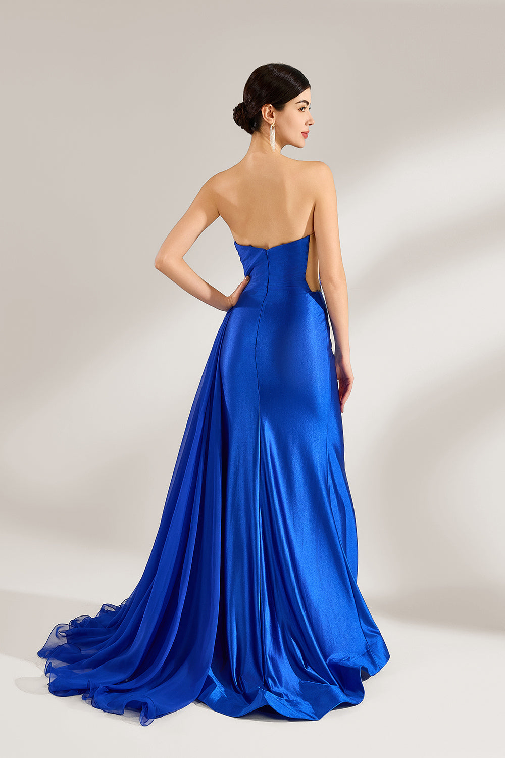 Set against a light background, a woman wears a royal - blue strapless gown. It features a sparkling embellished neckline, a high side slit, and a flowing train. The elegant design creates a glamorous and sophisticated look, perfect for formal events like galas or red - carpet moments.2