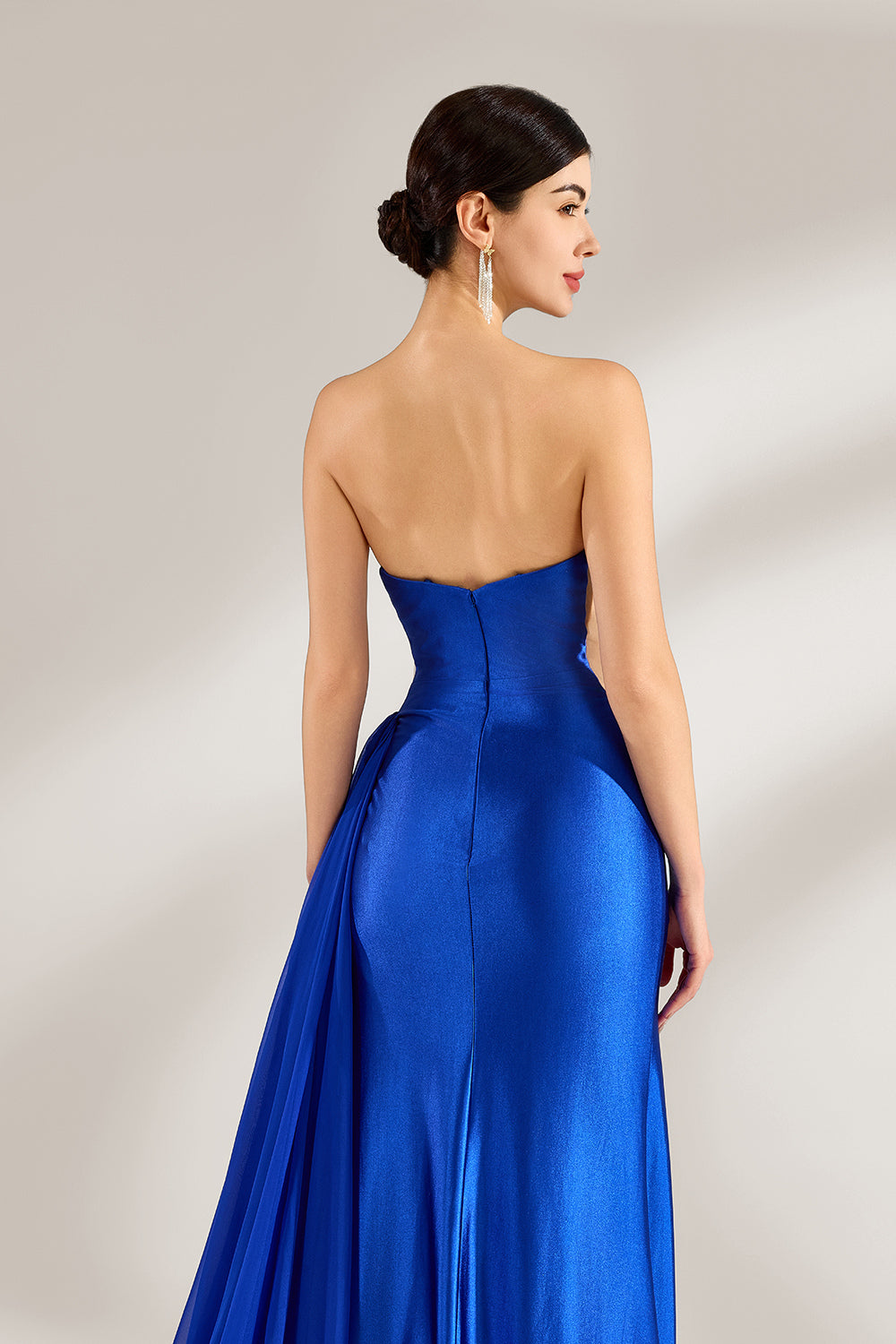 Set against a light background, a woman wears a royal - blue strapless gown. It features a sparkling embellished neckline, a high side slit, and a flowing train. The elegant design creates a glamorous and sophisticated look, perfect for formal events like galas or red - carpet moments.6