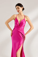 A woman stands against a light background, wearing a hot - pink satin gown. It features thin straps, a deep V - neckline, a draped bodice, a high side slit with crystal embellishments, and a trailing skirt. The elegant design creates a glamorous look, perfect for formal events like galas or red - carpet occasions.4