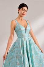 A woman with an elegant updo and a graceful stance wears a light - blue, floral - jacquard gown. It has a deep V - neck, sleeveless design, and a voluminous skirt. Paired with understated heels, the outfit radiates charm, perfect for formal events like galas or weddings.4