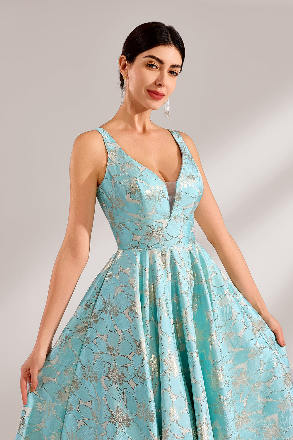 A woman with an elegant updo and a graceful stance wears a light - blue, floral - jacquard gown. It has a deep V - neck, sleeveless design, and a voluminous skirt. Paired with understated heels, the outfit radiates charm, perfect for formal events like galas or weddings.4
