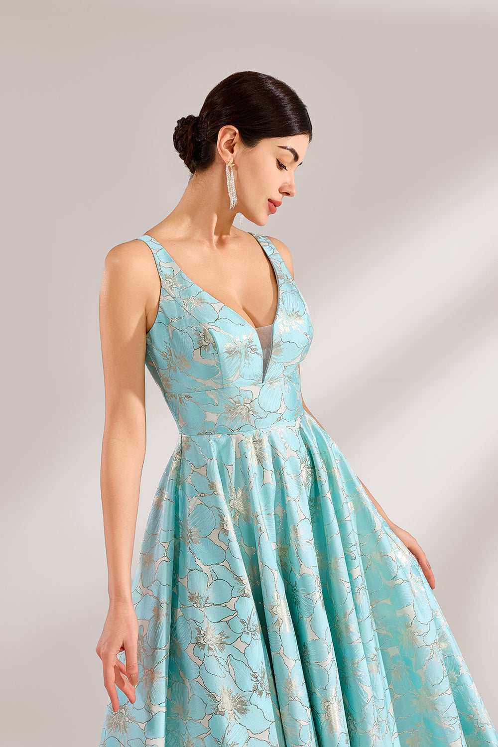 A woman with an elegant updo and a graceful stance wears a light - blue, floral - jacquard gown. It has a deep V - neck, sleeveless design, and a voluminous skirt. Paired with understated heels, the outfit radiates charm, perfect for formal events like galas or weddings.5