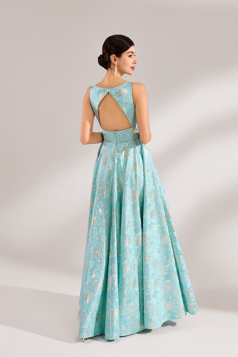 A woman with an elegant updo and a graceful stance wears a light - blue, floral - jacquard gown. It has a deep V - neck, sleeveless design, and a voluminous skirt. Paired with understated heels, the outfit radiates charm, perfect for formal events like galas or weddings.2