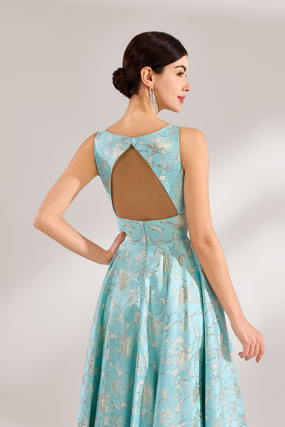 A woman with an elegant updo and a graceful stance wears a light - blue, floral - jacquard gown. It has a deep V - neck, sleeveless design, and a voluminous skirt. Paired with understated heels, the outfit radiates charm, perfect for formal events like galas or weddings.6
