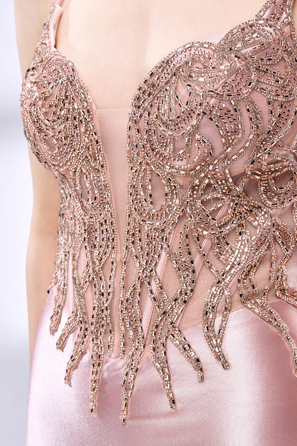 Set against a light backdrop, a woman dons a pink satin gown with a beaded, sheer bodice and a mermaid silhouette. The intricate bead patterns and flowing train add romance, combining sophistication and allure. Ideal for weddings or formal ceremonies, it exudes a regal aura.6