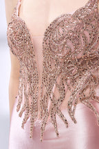Set against a light backdrop, a woman dons a pink satin gown with a beaded, sheer bodice and a mermaid silhouette. The intricate bead patterns and flowing train add romance, combining sophistication and allure. Ideal for weddings or formal ceremonies, it exudes a regal aura.6
