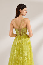 Bathed in soft light, a woman dazzles in a yellow floral - patterned gown. It has thin straps, a fitted bodice, and a high side slit. The flowing skirt creates an elegant and vibrant look, perfect for formal events or special occasions.6