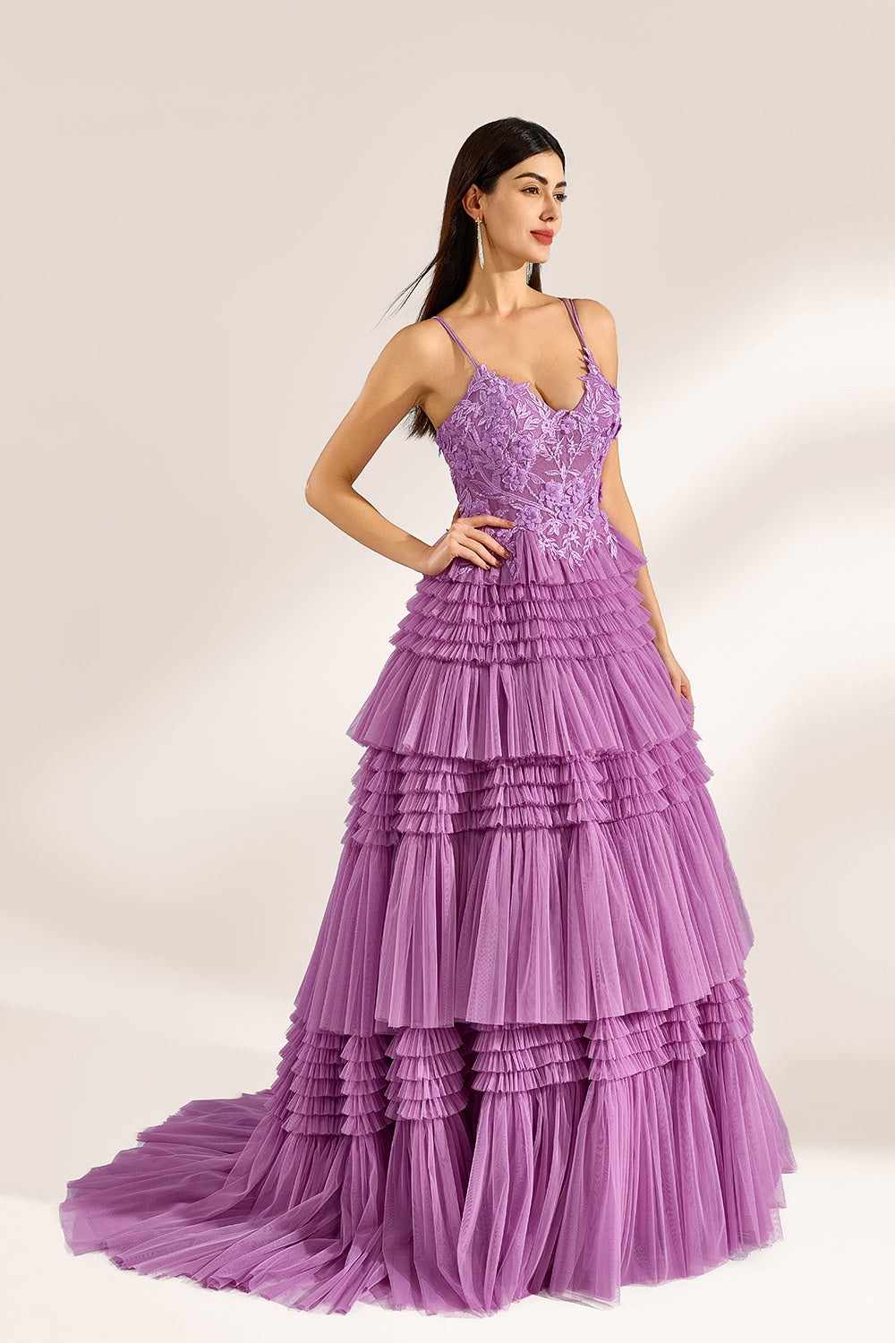 A woman stands against a light background, wearing a lavender tulle gown. It has thin straps, a deep V - neckline, and intricate floral lace embroidery on the bodice. The multi - layered, ruffled tulle skirt with a train creates a romantic and voluminous look, perfect for formal events like weddings or proms, exuding elegance and charm.
1