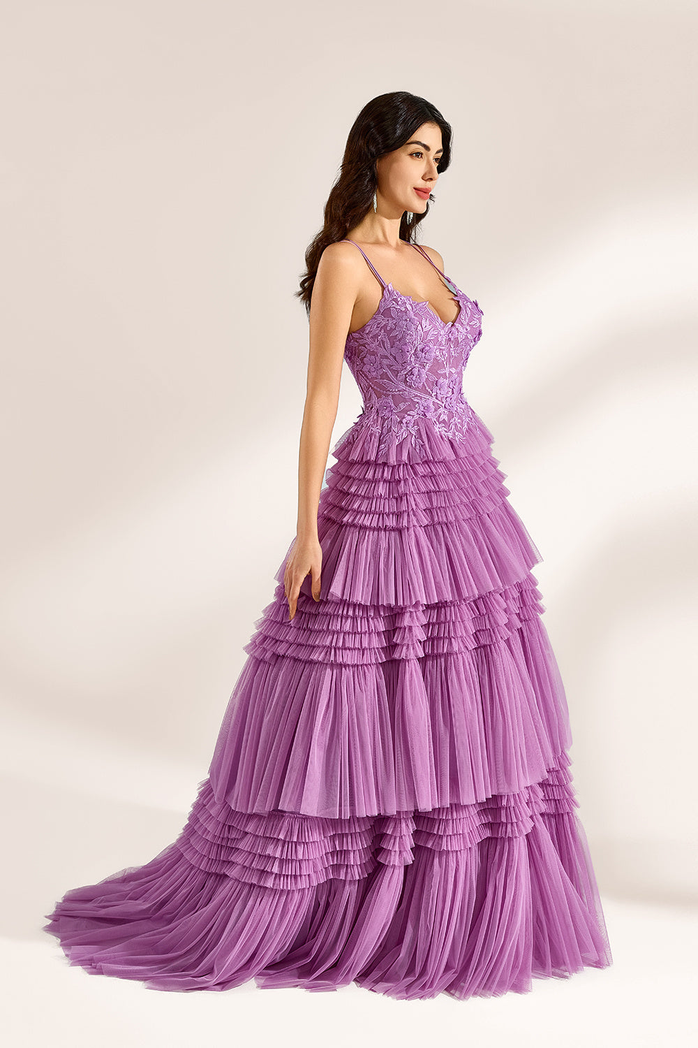 A woman stands against a light background, wearing a lavender tulle gown. It has thin straps, a deep V - neckline, and intricate floral lace embroidery on the bodice. The multi - layered, ruffled tulle skirt with a train creates a romantic and voluminous look, perfect for formal events like weddings or proms, exuding elegance and charm.
3
